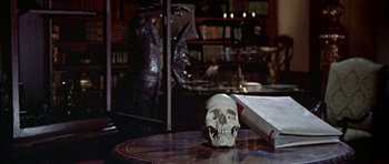 Movie still from “The Skull” (1965), directed by Freddie Francis – A human skull with a knife on top of a table; Close Up shot, High angle