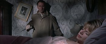 Movie still from “The Skull” (1965), directed by Freddie Francis – A man standing next to a bed in a room; Medium shot, Over the shoulder angle