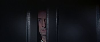 Movie still from “The Skull” (1965), directed by Freddie Francis – A man standing behind bars looking out of a window; Close Up shot, Low angle