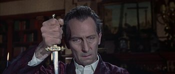 Movie still from “The Skull” (1965), directed by Freddie Francis – A person holding a sword; Close Up shot, Low angle