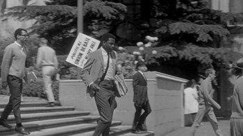 Movie still from “The Slender Thread” (1965), directed by Sydney Pollack – A black and white photo of a man walking down the street; Wide shot, Low angle