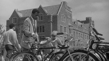 Movie still from “The Slender Thread” (1965), directed by Sydney Pollack – A black and white photo of a man on a bicycle; Wide shot, Low angle