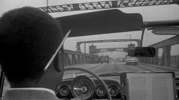 Movie still from “The Slender Thread” (1965), directed by Sydney Pollack – A black and white photo of a man driving a car on a bridge; Close Up shot, Over the shoulder angle