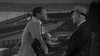 Movie still from “The Slender Thread” (1965), directed by Sydney Pollack – Two men are standing next to each other talking; Medium shot, Over the shoulder angle