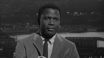 Movie still from “The Slender Thread” (1965), directed by Sydney Pollack – A black and white photo of a man in a suit and tie; Close Up shot, Low angle