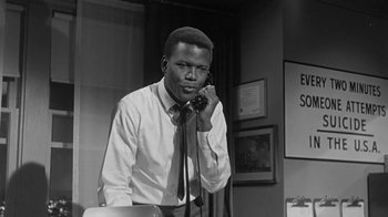 Movie still from “The Slender Thread” (1965), directed by Sydney Pollack – A black and white photo of a man talking on a phone; Medium shot, Low angle