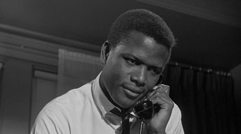 Movie still from “The Slender Thread” (1965), directed by Sydney Pollack – A black and white photo of a man talking on a phone; Close Up shot, Low angle