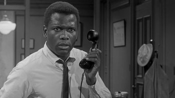 Movie still from “The Slender Thread” (1965), directed by Sydney Pollack – A black and white photo of a man holding a phone; Close Up shot, Low angle