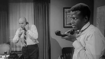 Movie still from “The Slender Thread” (1965), directed by Sydney Pollack – Two men in a room talking on the phone; Medium shot, Low angle