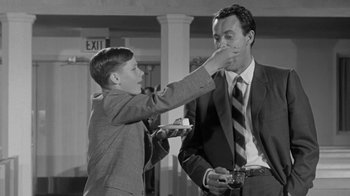 Movie still from “The Slender Thread” (1965), directed by Sydney Pollack – A young boy feeding a man a piece of food; Medium shot, Low angle