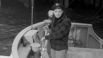 Movie still from “The Slender Thread” (1965), directed by Sydney Pollack – A black and white photo of a man on a boat; Medium shot, High angle