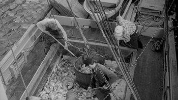 Movie still from “The Slender Thread” (1965), directed by Sydney Pollack – A group of men working on a boat in the water; Wide shot, High angle