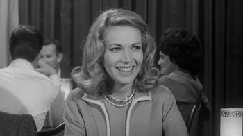 Movie still from “The Slender Thread” (1965), directed by Sydney Pollack – A black and white photo of a woman smiling for the camera; Close Up shot, Over the shoulder angle