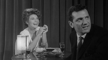 Movie still from “The Slender Thread” (1965), directed by Sydney Pollack – An old photo of a man and a woman sitting at a dinner table; Medium shot, Low angle