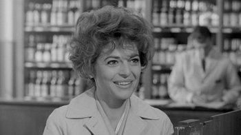 Movie still from “The Slender Thread” (1965), directed by Sydney Pollack – An old black and white photo of a woman smiling; Close Up shot, Over the shoulder angle