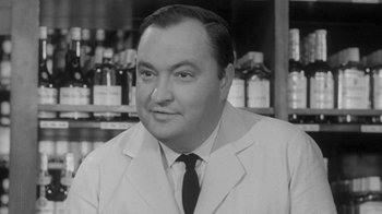 Movie still from “The Slender Thread” (1965), directed by Sydney Pollack – An old black and white photo of a man wearing a suit; Close Up shot, Low angle