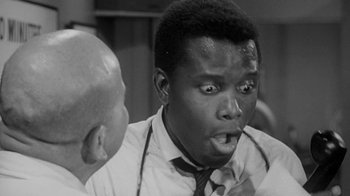Movie still from “The Slender Thread” (1965), directed by Sydney Pollack – A black and white photo of a man with a surprised look on his face; Close Up shot, Over the shoulder angle