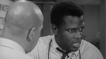Movie still from “The Slender Thread” (1965), directed by Sydney Pollack – A man in a tie is talking to another man in a white shirt; Close Up shot, Over the shoulder angle