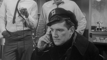 Movie still from “The Slender Thread” (1965), directed by Sydney Pollack – A black and white photo of a man talking on a phone; Close Up shot, Low angle