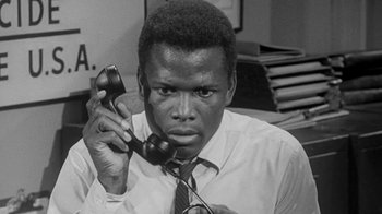 Movie still from “The Slender Thread” (1965), directed by Sydney Pollack – A black and white photo of a man holding a phone to his ear; Close Up shot, High angle