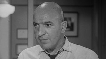 Movie still from “The Slender Thread” (1965), directed by Sydney Pollack – An older man with a shaved head wearing a shirt and tie; Close Up shot, Low angle