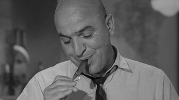 Movie still from “The Slender Thread” (1965), directed by Sydney Pollack – A bald man wearing a tie and holding a cigarette in his mouth; Close Up shot, Low angle
