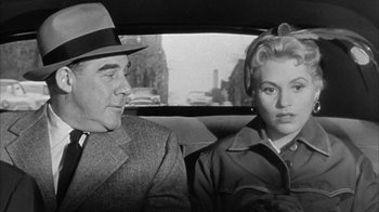 Movie still from “The Solid Gold Cadillac” (1956), directed by Richard Quine – A man and a woman sitting in the back of a car; Medium shot, Over the shoulder angle