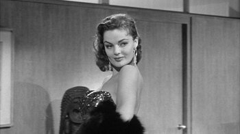 Movie still from “The Solid Gold Cadillac” (1956), directed by Richard Quine – A black - and - white photo of a woman posing for a picture; Close Up shot, Low angle