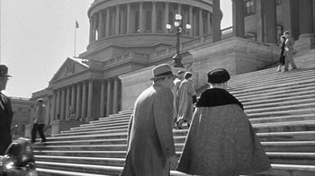 Movie still from “The Solid Gold Cadillac” (1956), directed by Richard Quine – A group of people walking down the steps of a building; Extreme Wide shot, Low angle