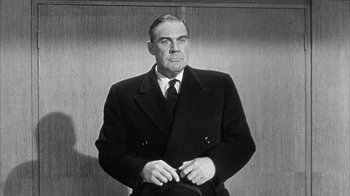 Movie still from “The Solid Gold Cadillac” (1956), directed by Richard Quine – An older man wearing a suit and tie; Medium shot, Low angle