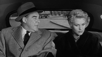 Movie still from “The Solid Gold Cadillac” (1956), directed by Richard Quine – An older man and a woman in a car; Medium shot, High angle