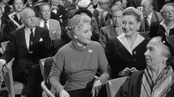 Movie still from “The Solid Gold Cadillac” (1956), directed by Richard Quine – A group of people sitting in chairs in a room; Medium shot, Over the shoulder angle