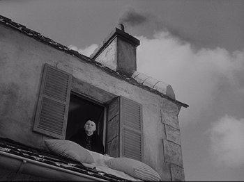 Movie still from “The Song of Bernadette” (1943), directed by Henry King – A person with a mask looking out of a window; Wide shot, Low angle