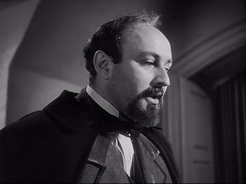 Movie still from “The Song of Bernadette” (1943), directed by Henry King – A man with a goatee and beard wearing a suit and tie; Close Up shot, Low angle
