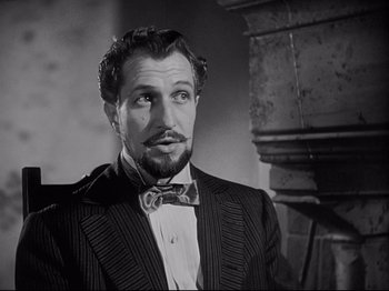 Movie still from “The Song of Bernadette” (1943), directed by Henry King – A black and white photo of a man wearing a suit and bow tie; Close Up shot, Low angle