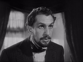 Movie still from “The Song of Bernadette” (1943), directed by Henry King – A black and white photo of a man in a suit; Close Up shot, Low angle