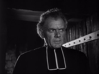 Movie still from “The Song of Bernadette” (1943), directed by Henry King – An older man wearing a priest's collar; Close Up shot, Low angle