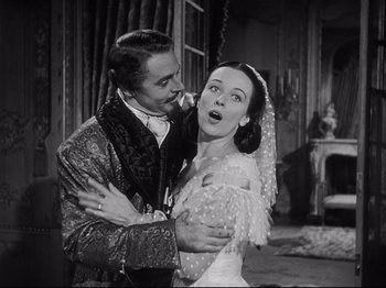 Movie still from “The Song of Bernadette” (1943), directed by Henry King – A man and a woman are hugging in an old photo; Medium shot, Low angle