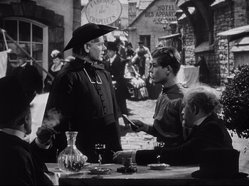 Movie still from “The Song of Bernadette” (1943), directed by Henry King – A group of people sitting around a table; Medium shot, Over the shoulder angle