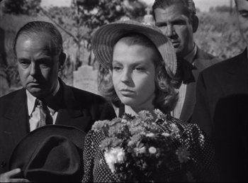 Movie still from “The Southerner” (1945), directed by Jean Renoir – An old black and white photo of a woman and two men; Medium shot, Low angle