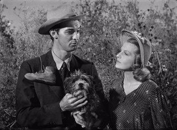 Movie still from “The Southerner” (1945), directed by Jean Renoir – A man and a woman holding a small dog; Medium shot, Low angle
