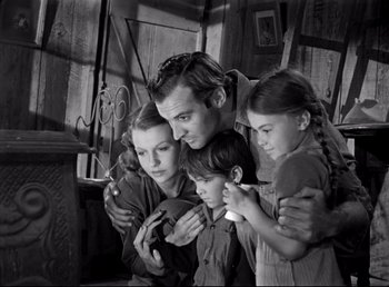 Movie still from “The Southerner” (1945), directed by Jean Renoir – A man and two girls and a little boy are looking at something; Medium shot, Low angle