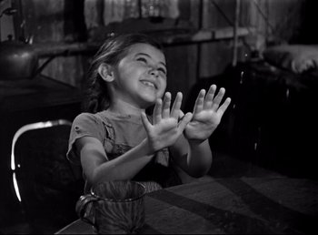 Movie still from “The Southerner” (1945), directed by Jean Renoir – A little girl clapping her hands in a black and white photo; Medium shot, High angle