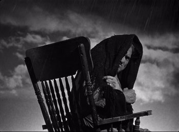 Movie still from “The Southerner” (1945), directed by Jean Renoir – A man sitting in a rocking chair under a blanket; Medium shot, Low angle