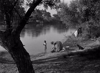 Movie still from “The Southerner” (1945), directed by Jean Renoir – A woman and a child near a body of water; Extreme Wide shot, High angle