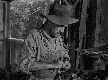 Movie still from “The Southerner” (1945), directed by Jean Renoir – A man wearing an overalls and a cowboy hat; Medium shot, Low angle