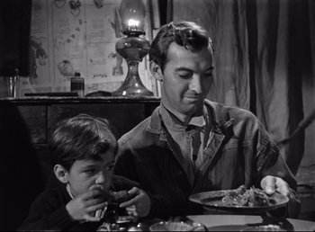 Movie still from “The Southerner” (1945), directed by Jean Renoir – A man and a boy sitting at a dinner table; Medium shot, Over the shoulder angle