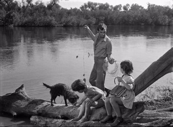 Movie still from “The Southerner” (1945), directed by Jean Renoir – A man and two children fishing on a river; Wide shot, High angle