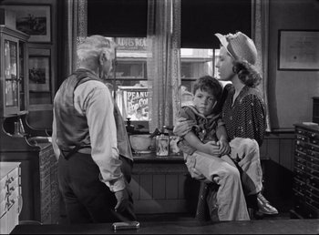 Movie still from “The Southerner” (1945), directed by Jean Renoir – An old photo of a man and a woman and a boy; Medium shot, Over the shoulder angle