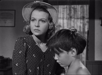 Movie still from “The Southerner” (1945), directed by Jean Renoir – A woman and a young boy are standing next to each other; Medium shot, Low angle